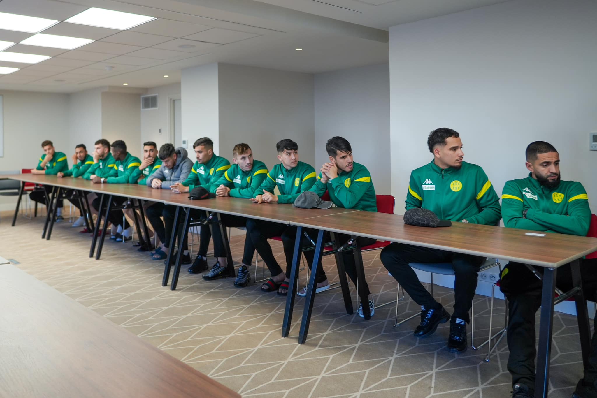 Peut être une image de 10 personnes, personnes jouant au football, table et texte