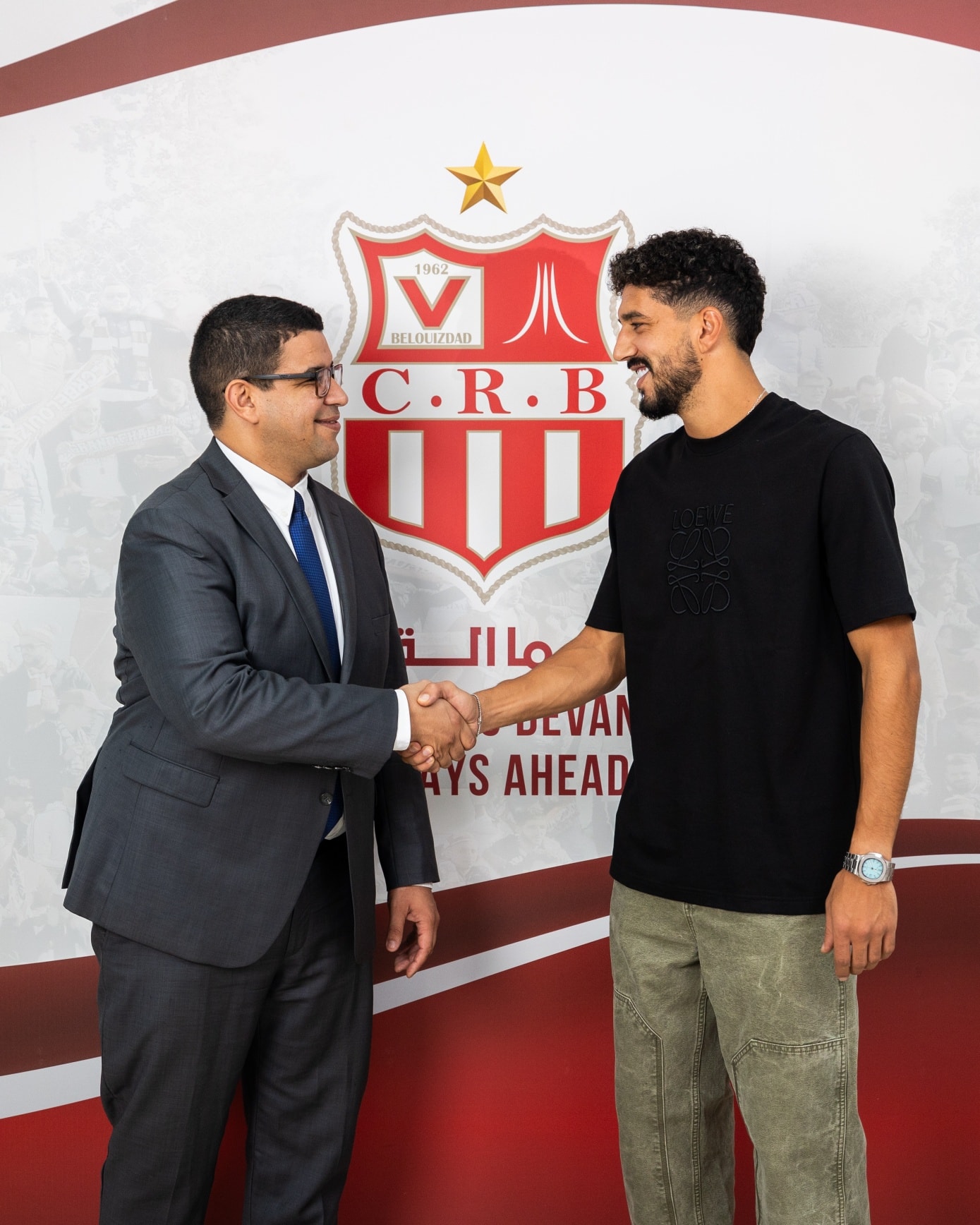 Peut être une image de ‎2 personnes, personnes jouant au football, personnes jouant au foot et ‎texte qui dit ’‎ル 1962 BELOLIZDAD C.R.B B UI مااة IVOLVAN BEVAN AYS AHEAD‎’‎‎